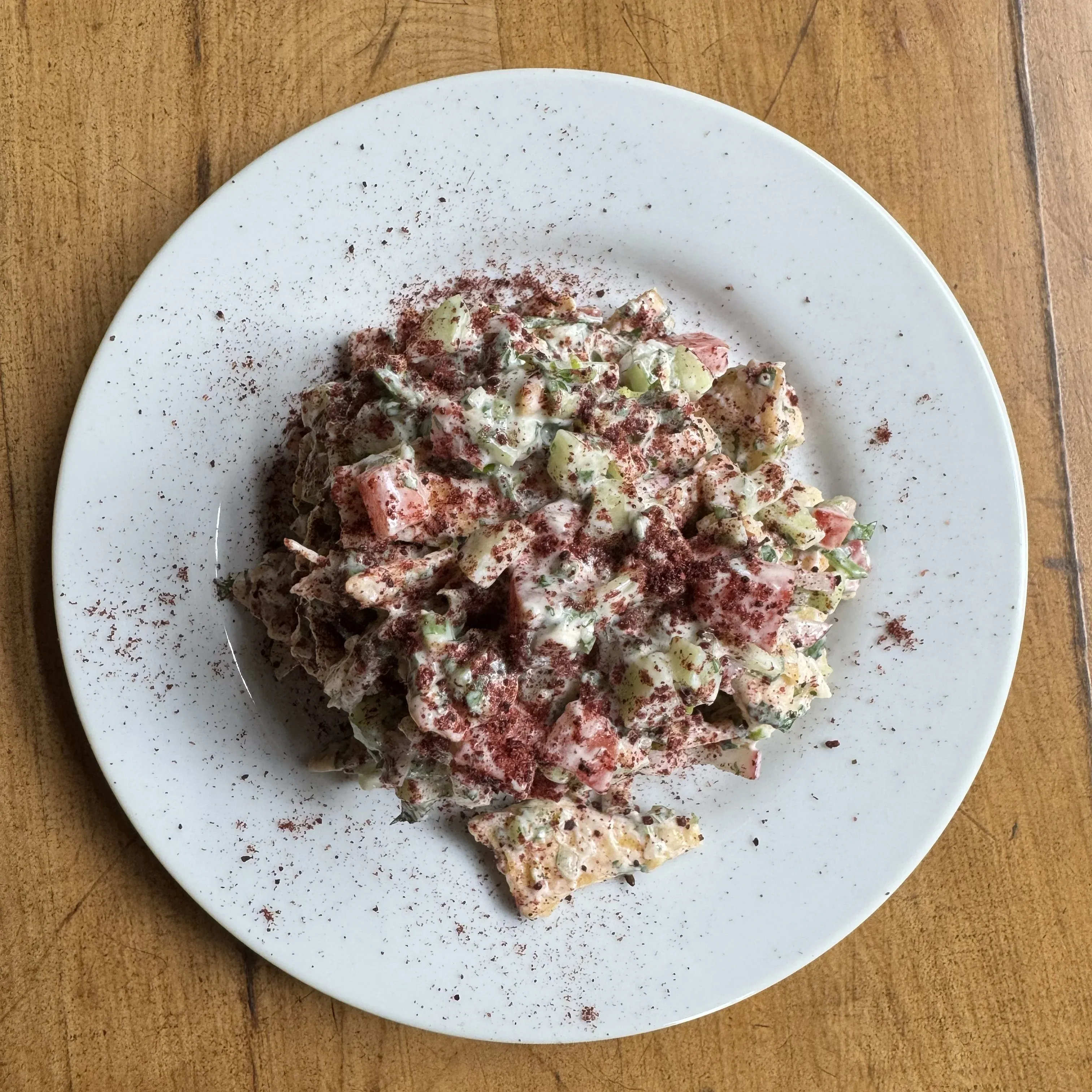 Ensalada fatush con pan pita crocante, labneh, rabanito, hierbas frescas y sumac