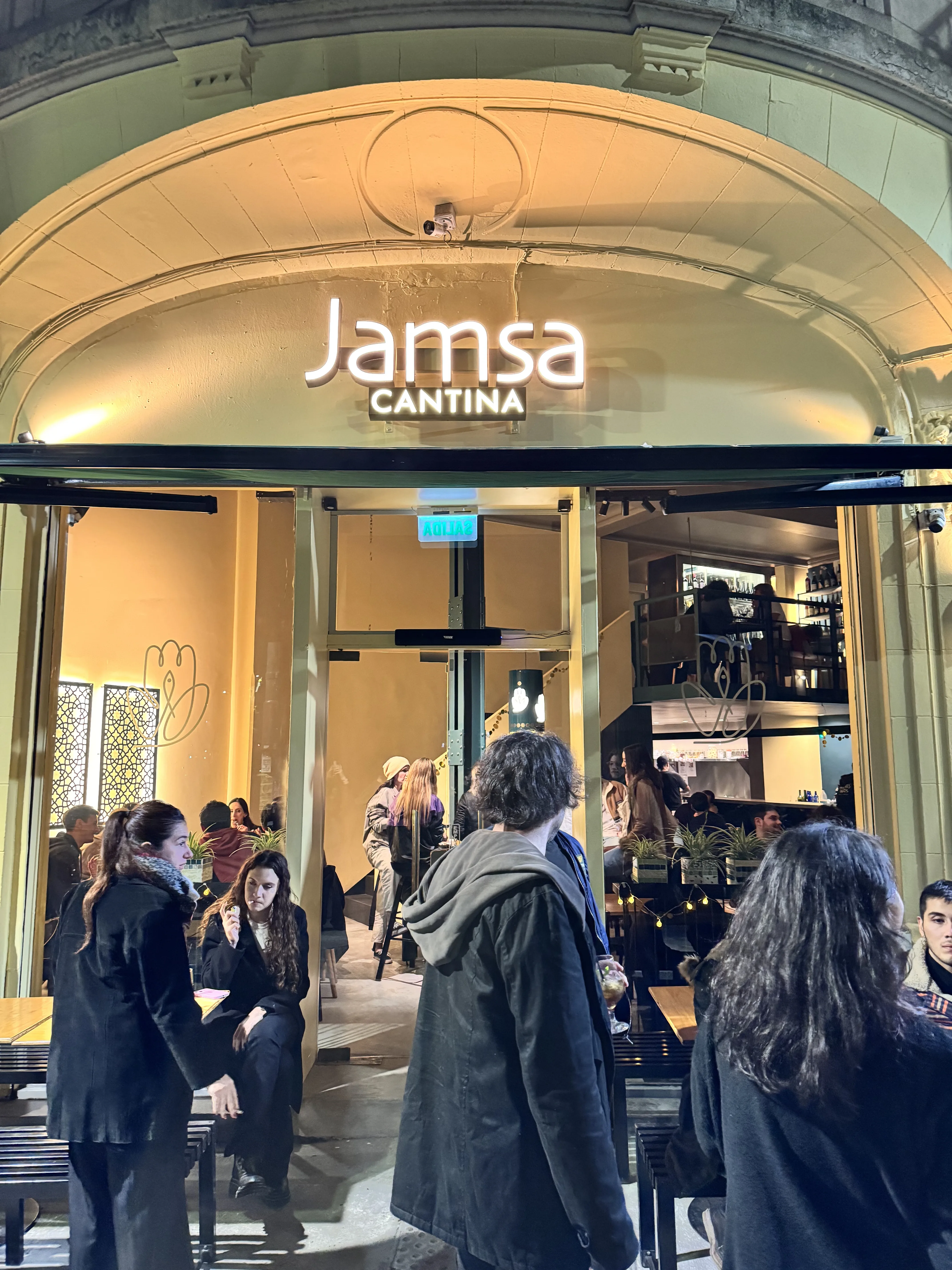 Fachada del restaurante de Medio Oriente Jamsa Cantina en Palermo de noche, con el comedor a la vista