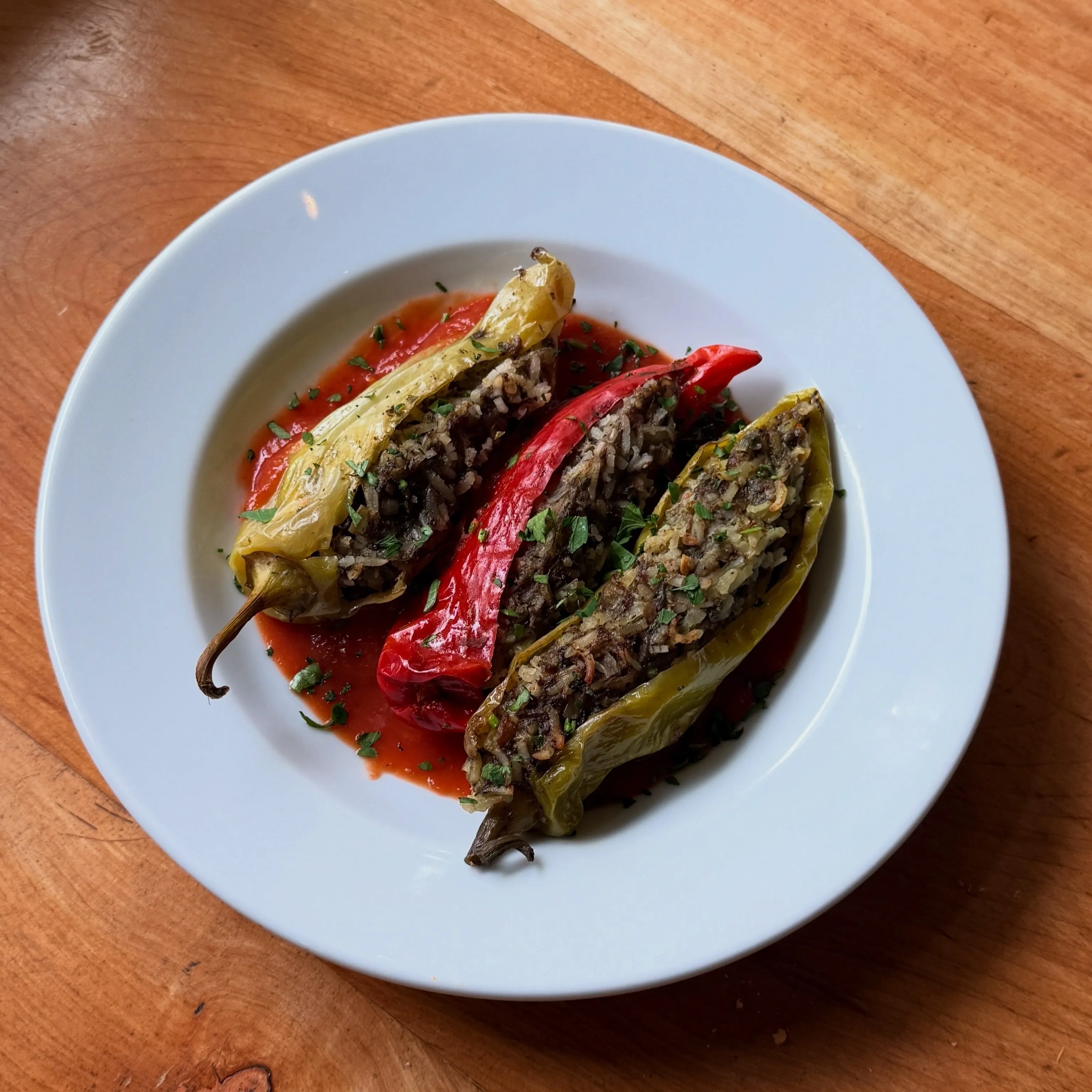 Pimientos rellenos con arroz y cordero sobre salsa de tomate especiada con harissa