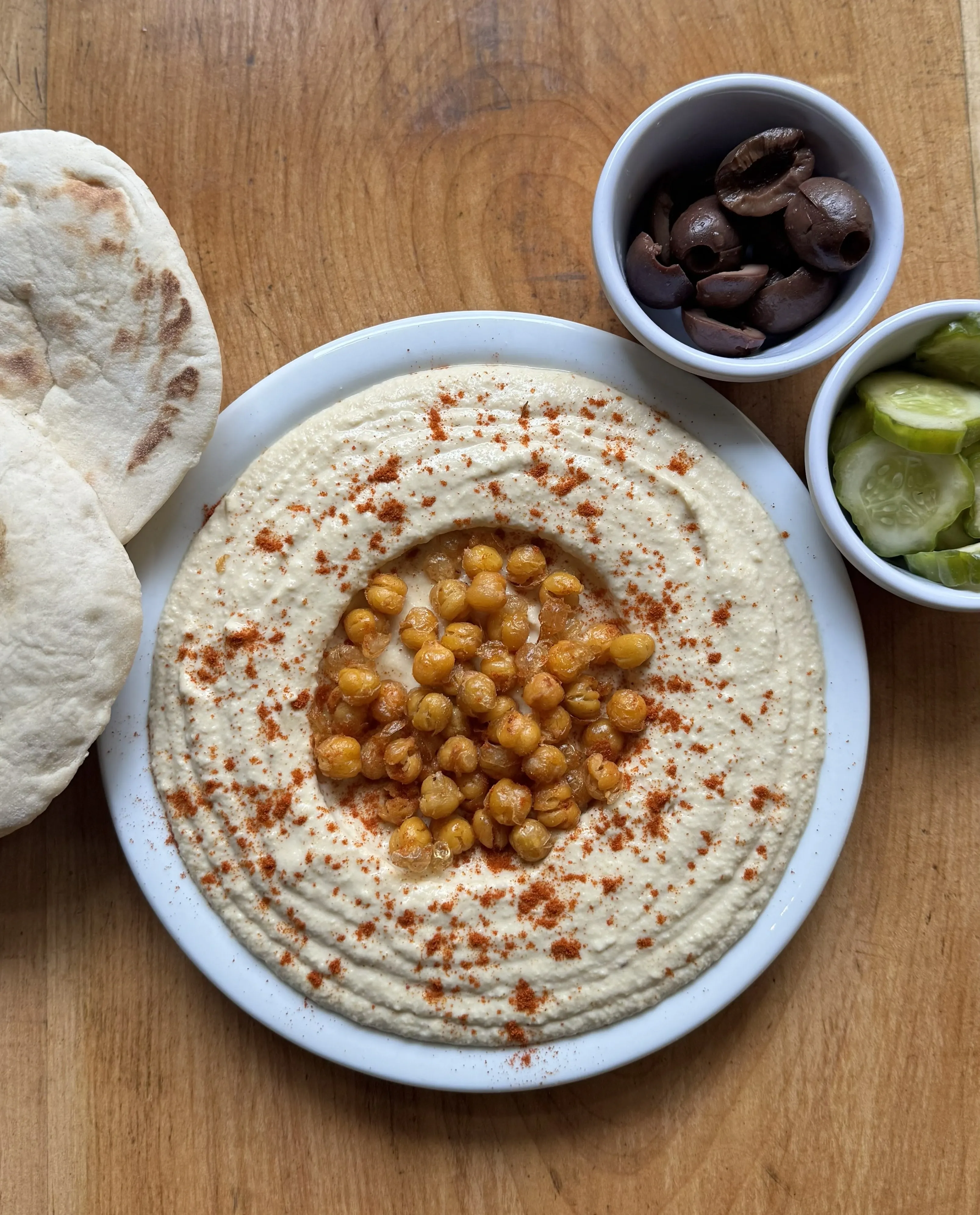 Mesa servida con shakshuka, hummus, pan pita casero y platos tradicionales de Jamsa cocina árabe